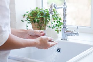 Frau beim Spülen einer Tasse