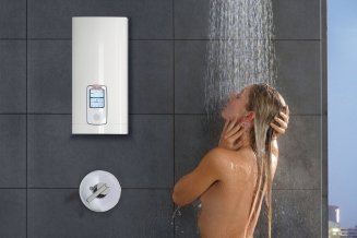Durchlauferhitzer Stiebel Eltron DHE Connect 18/21/24 an der Wand neben einer duschenden Frau hängend